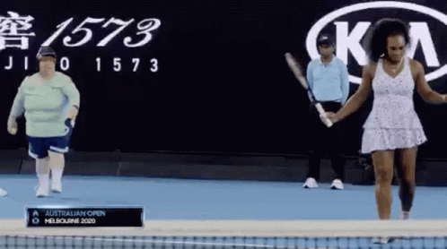 A Woman In A White Dress Is Holding A Tennis Racquet In Front Of A Kia Logo GIF
