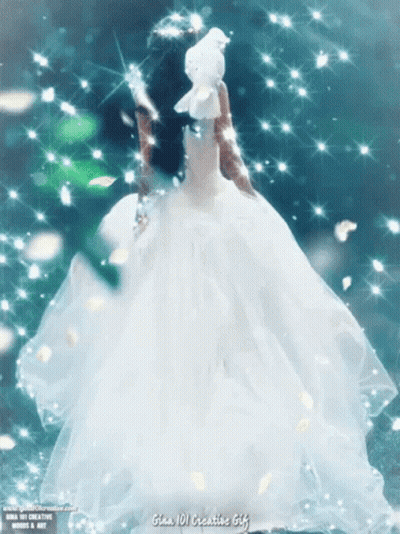 A Woman In A White Dress Is Holding A White Dove In Her Hand GIF