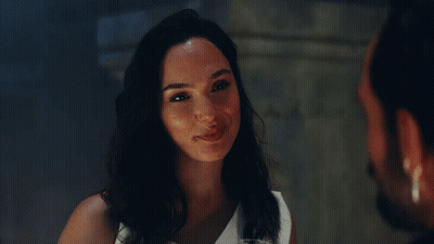 A Woman In A White Dress Is Smiling At A Man GIF