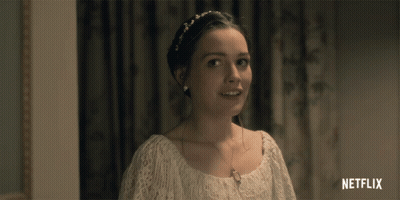 A Woman In A White Dress Is Smiling With A Netflix Logo In The Corner GIF