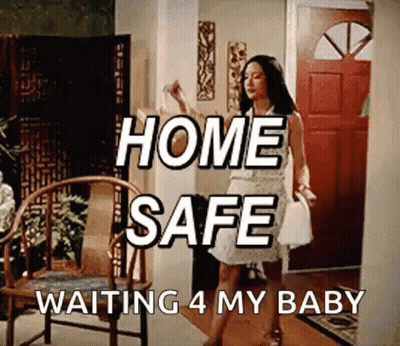 A Woman In A White Dress Is Standing In A Living Room With The Words Home Safe Waiting 4 My Baby Written Above Her GIF