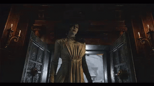 A Woman In A White Dress Is Standing In A Room With Candles . GIF