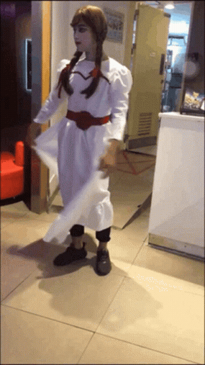A Woman In A White Dress Is Standing In Front Of A Counter GIF
