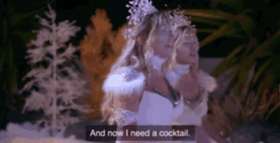 A Woman In A White Dress Is Standing In Front Of A Snowy Forest And Says `` And Now I Need A Cocktail '' . GIF