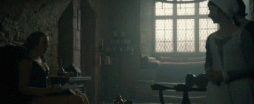 A Woman In A White Dress Is Standing Next To A Man In A Black Shirt GIF