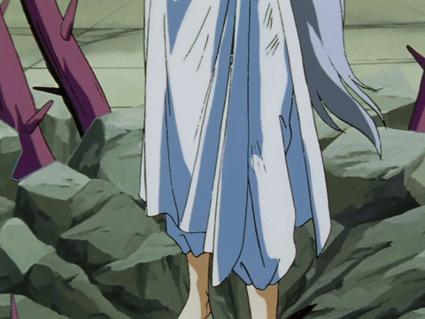 A Woman In A White Dress Is Standing On A Rocky Surface GIF