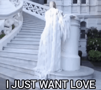 A Woman In A White Dress Is Standing On A Set Of Stairs With The Words I Just Want Love Above Her . GIF