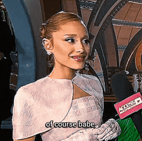 A Woman In A White Dress Is Talking Into A Microphone And The Words Of Course Babe Are Next To Her GIF