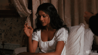 A Woman In A White Dress Sits On A Bed With A Netflix Logo On The Bottom GIF