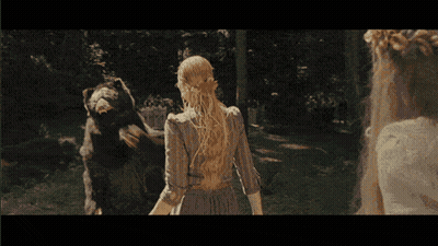 A Woman In A White Dress Stands In Front Of A Large Bear GIF