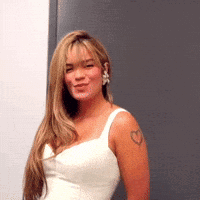 A Woman In A White Dress With A Heart Tattoo On Her Arm GIF