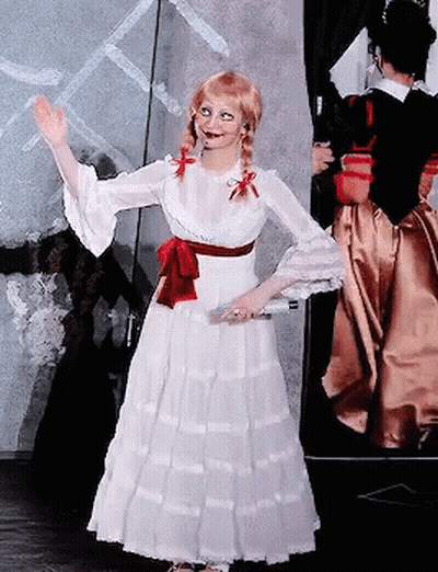 A Woman In A White Dress With A Red Bow On Her Waist GIF