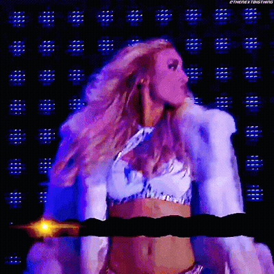 A Woman In A White Fur Coat Is Standing In Front Of A Purple Background GIF