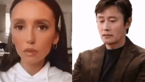 A Woman In A White Hoodie And A Man In A Brown Suit GIF