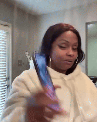 A Woman In A White Hoodie Is Holding A Cell Phone . GIF