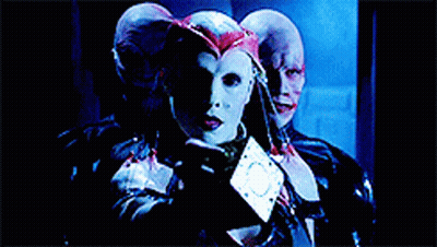 A Woman In A White Mask Is Surrounded By Two Men GIF