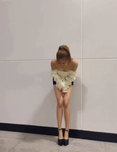 A Woman In A White Off The Shoulder Top And Shorts Is Dancing . GIF