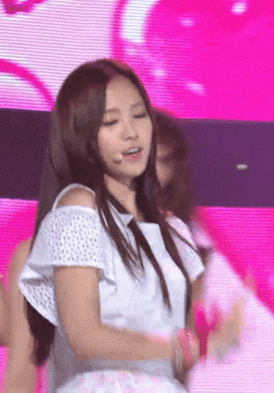A Woman In A White Off The Shoulder Top Is Dancing On A Stage GIF