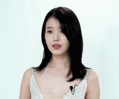 A Woman In A White Sequined Dress Has A Microphone On Her Chest GIF