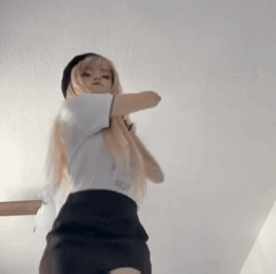A Woman In A White Shirt And Black Skirt Is Standing In A Room . GIF