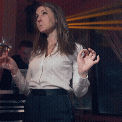 A Woman In A White Shirt Holds A Glass Of Wine In Front Of A Yamaha Keyboard GIF