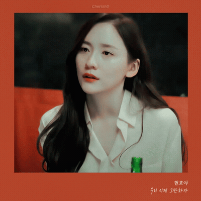 A Woman In A White Shirt Holds A Green Bottle In Her Hand GIF