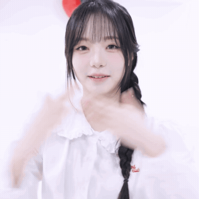 A Woman In A White Shirt Holds Her Hands To Her Chest GIF