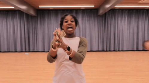 A Woman In A White Shirt Is Holding A Bunch Of Money GIF