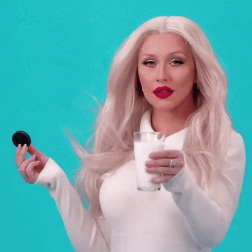 A Woman In A White Shirt Is Holding A Cookie GIF