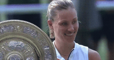 A Woman In A White Shirt Is Holding A Trophy GIF