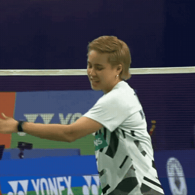 A Woman In A White Shirt Is Playing Badminton In Front Of A Yonex Advertisement GIF