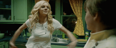 A Woman In A White Shirt Is Standing In A Kitchen With Her Arms Outstretched GIF
