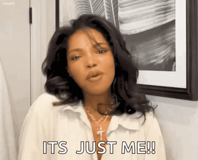 A Woman In A White Shirt Is Standing In Front Of A Picture Frame And Says It 'S Just Me ! GIF