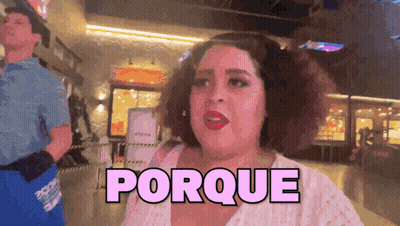 A Woman In A White Shirt Is Standing In Front Of A Sign That Says " Porque " GIF