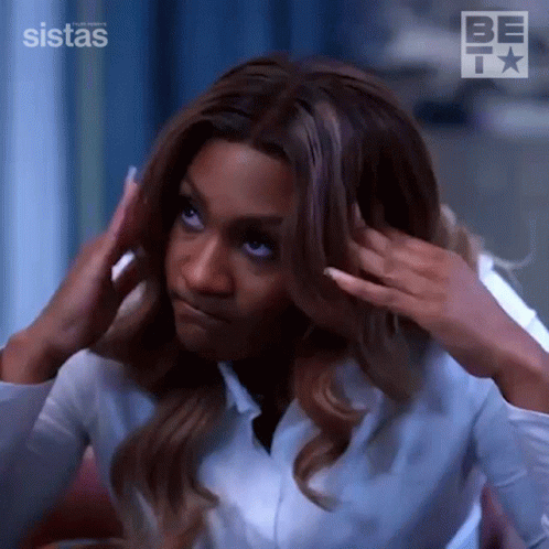 A Woman In A White Shirt Is Touching Her Hair And Making A Face . GIF