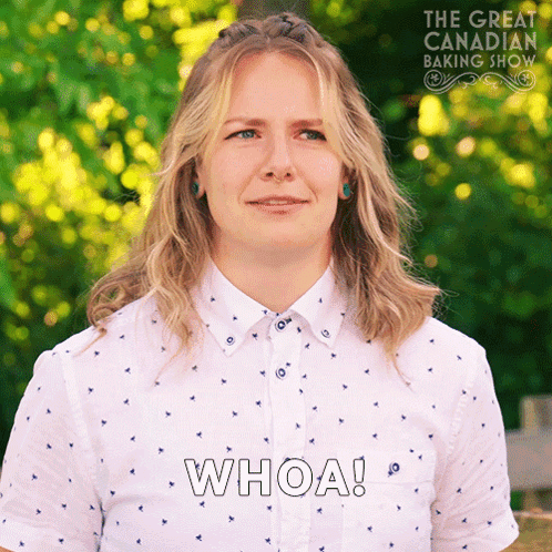 A Woman In A White Shirt Says Whoa In Front Of A Great Canadian Baking Show Logo GIF