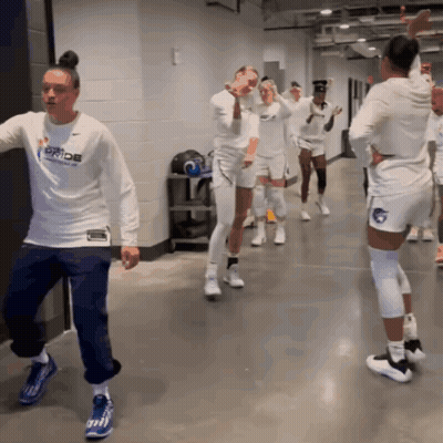 A Woman In A White Shirt That Says Pride Is Dancing GIF