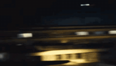 A Woman In A White Shirt With A Hole In It Is Standing In A Dark Room . GIF