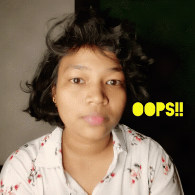a woman in a white shirt with oops written in yellow