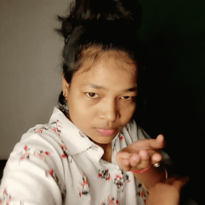 A Woman In A White Shirt With Red Flowers On It Holds Out Her Hand GIF