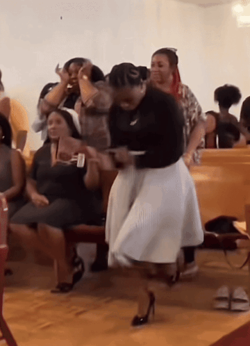 A Woman In A White Skirt Is Dancing In Front Of A Group Of People GIF