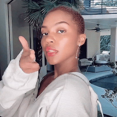 A Woman In A White Sweater Giving A Thumbs Up Sign GIF