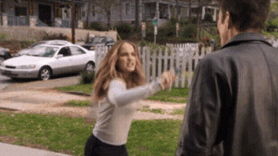 A Woman In A White Sweater Is Fighting A Man In A Black Jacket GIF