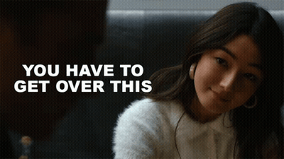 A Woman In A White Sweater With The Words " You Have To Get Over This " Behind Her GIF