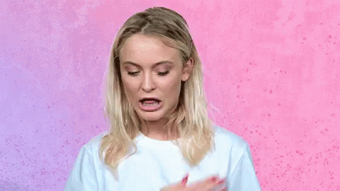 A Woman In A White T-Shirt Is Making A Funny Face . GIF