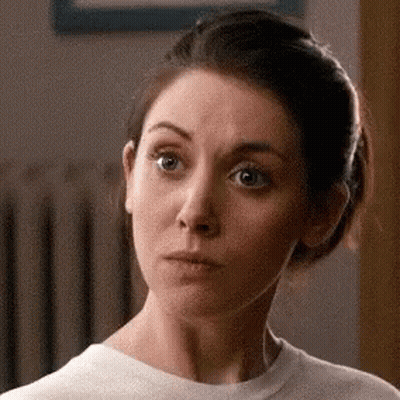 A Woman In A White T-Shirt Is Making A Funny Face . GIF