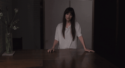 A Woman In A White T-Shirt Is Pointing At Her Chest GIF