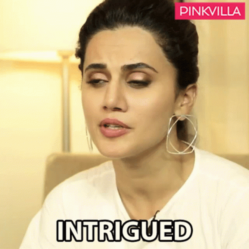 A Woman In A White T-Shirt With The Word Intrigued On The Bottom GIF