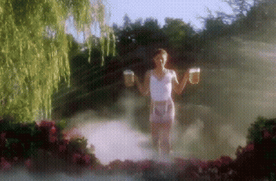 A Woman In A White Tank Top And Pink Shorts Is Holding Two Beer Mugs In Her Hands . GIF
