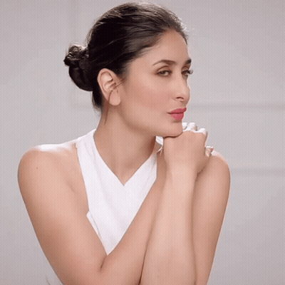 A Woman In A White Tank Top Has Her Hands On Her Face GIF
